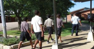 Image of detainess restrained by handcuffs moving between buildings with the Banksia Hill Detention Centre after the riot