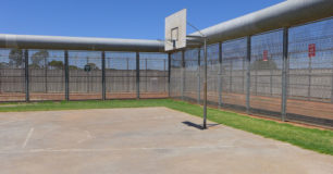 Photo of basketball court surrounded by security fence