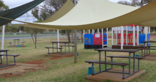 Photo of Min security visits area, picnic tables on grass under shade sails