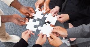 Image of five sets of hands holding four white jig saw pieces