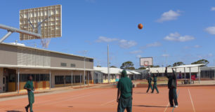 Image of prisoners on a basketball court, outside recreation