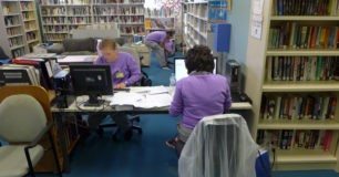 Women using computers in custodial library