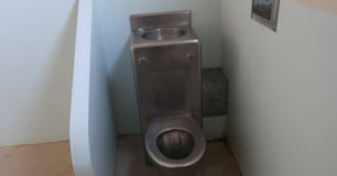 Image of an old style toilet and drinking water station in a court custody cell