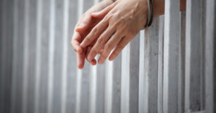 Prisoner handcuffed and behind bars