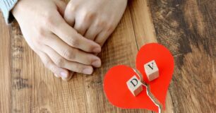 Image of a torn red paper heart with two wooden blocks with the letter D one one block and V on the other