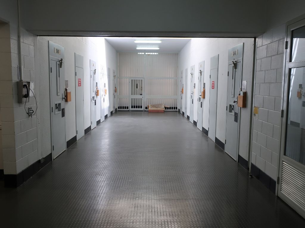 Image of cell doors in a row either side of a corridor in the SHU at Casuarina Prison